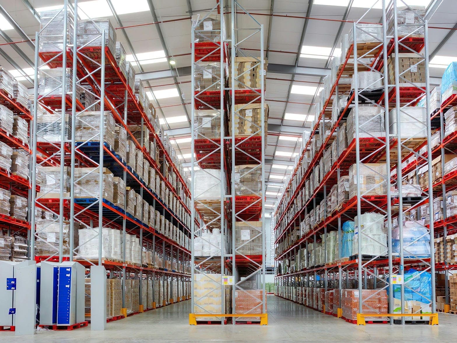 High-bay warehouse aisle with pallet racking and inventory in daylight